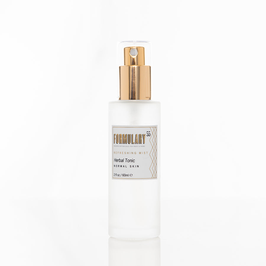 A translucent spray bottle of Formulary 55 Refreshing Mist Herbal Tonic for normal skin is displayed against a white background. The bottle has a gold spray cap and a label detailing the product name and size of 2 fl oz (50 ml).