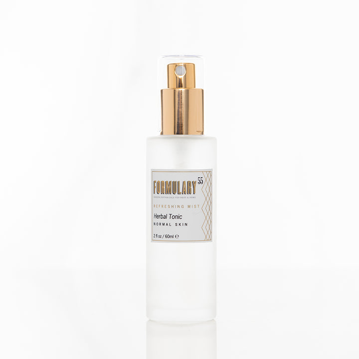 A translucent spray bottle of Formulary 55 Refreshing Mist Herbal Tonic for normal skin is displayed against a white background. The bottle has a gold spray cap and a label detailing the product name and size of 2 fl oz (50 ml).